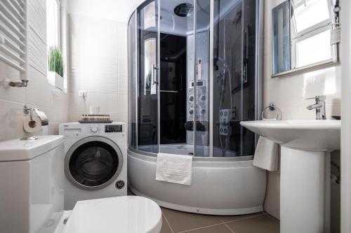 uma casa de banho com uma máquina de lavar roupa e um lavatório em Chameleon Apartment Budapest em Budapeste
