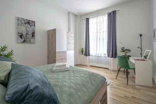 um quarto com uma cama, uma secretária e uma janela em Chameleon Apartment Budapest em Budapeste