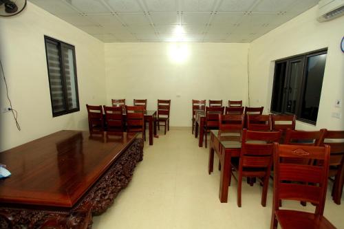 una sala da pranzo con tavoli e sedie in legno di Tam Coc Mountain Flower Homestay a Vũ Lâm