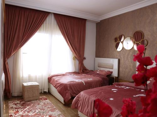 um quarto com 2 camas e uma janela em Royal Mansion with private pool in sheikh zayed Compound families em Sheikh Zayed