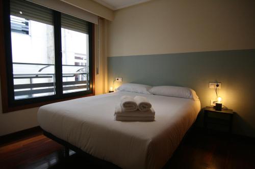 a bedroom with a bed with two towels on it at 2F. El mejor lugar para descansar y vivir Ourense in Ourense