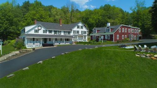 a large house on a road with a green lawn at Christmas Farm Inn and Spa in Jackson