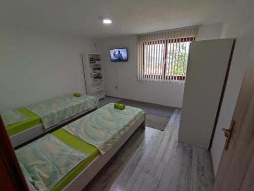 a room with two beds and a tv in it at Apartment Neo in Bihać