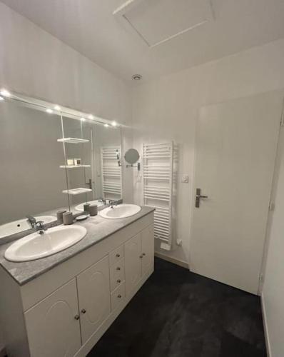 une salle de bain avec deux lavabos et un grand miroir dans l'établissement Vigne et mer-Spacieux Appartement Haussmannien-2chambres-Wifi, à Béziers