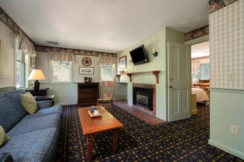 a living room with a blue couch and a fireplace at Christmas Farm Inn and Spa in Jackson
