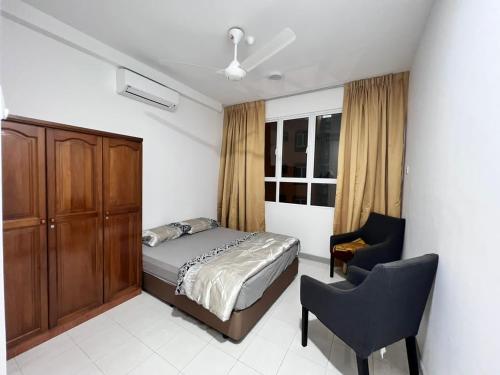 a bedroom with a bed and a desk and a chair at Qaisara Qais Homestay in Kuala Terengganu