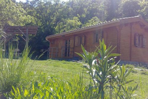 a small wooden house in a field of grass at Un chalet en bois dans un écrin de verdure in Aouste-sur-Sye