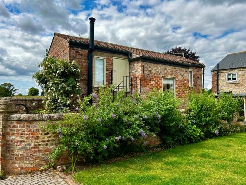 約克的住宿－Tanyard Cottage - Whixley, York, North Yorkshire，前面有花园的砖房