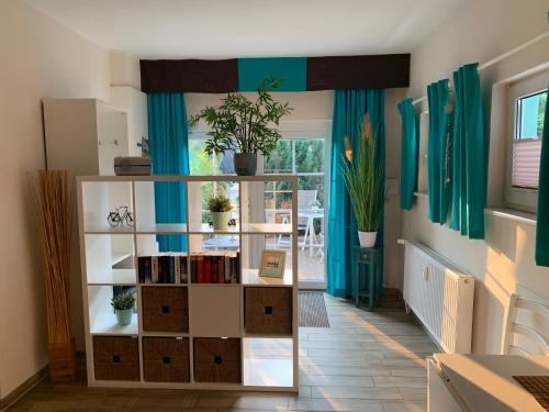 Habitación con cortinas azules y estante para libros. en Kleine Auszeit, en Rostock