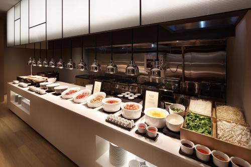 a kitchen with many bowls of food on a counter at Shilla Stay Seodaemun Seoul Station in Seoul