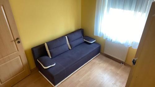 a blue couch in a room with a window at Mieszkanie w Giżycku in Giżycko