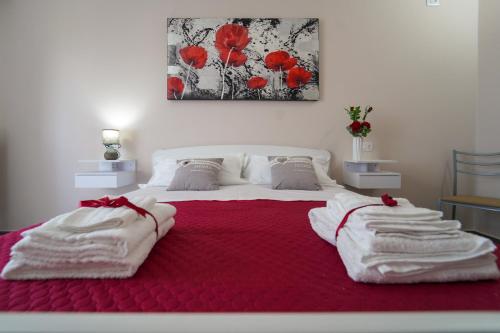 a bedroom with a large bed with red blanket and red flowers at Villa Falcone in Alvignano