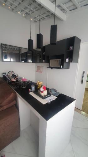 a kitchen with a black counter top in a room at Pousada Charme Charmant in Praia Grande