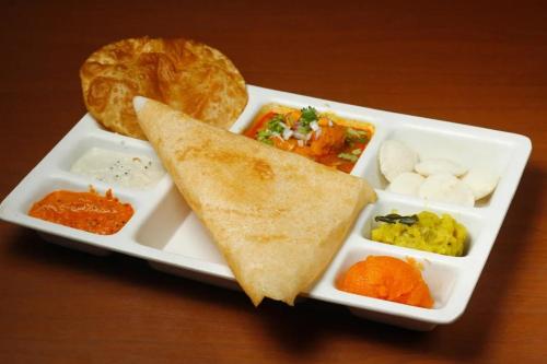 a plate of food with a sandwich and other foods at Pine Tree Signature in Chennai
