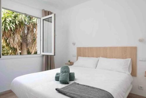 een slaapkamer met een groot wit bed en een raam bij Aptos dOr in Cala d´Or