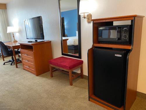 a hotel room with a microwave and a television at Wingate by Wyndham Mount Vernon in Mount Vernon