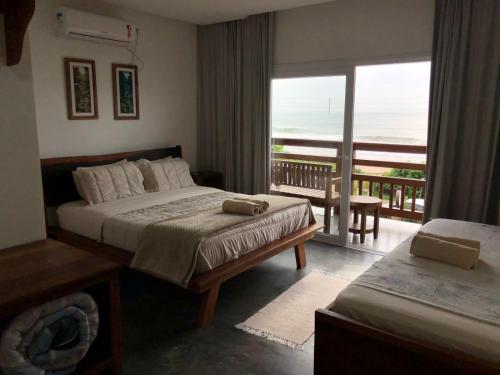 um quarto com uma cama e vista para o oceano em Pousada Casa Albatross em Penha