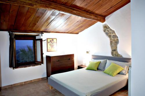 a bedroom with a bed and a wooden ceiling at Casa MarJù in Montemassi