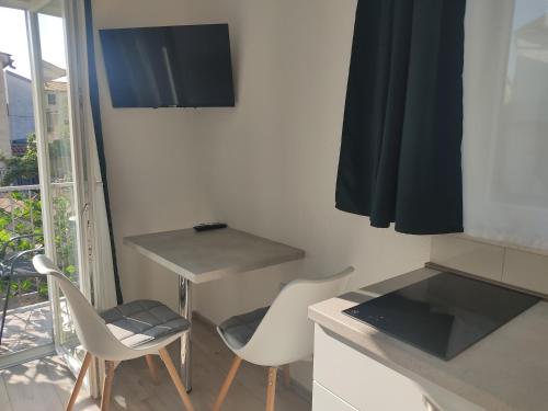 a small kitchen with a table and two chairs at Studio apartman in Turanj
