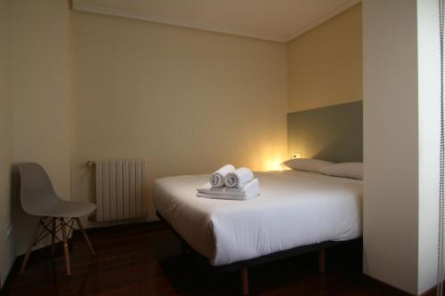 een hotelkamer met een bed met handdoeken erop bij 3B.Descansa y disfruta en el corazón de las Burgas in Ourense