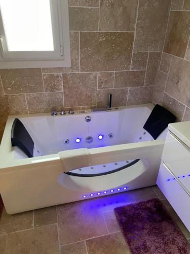 a bath tub with purple lights in a bathroom at Loft atlantique Rochefort in Rochefort