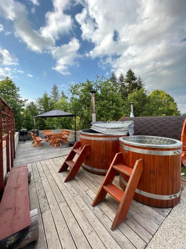 eine Terrasse mit zwei großen hölzernen Badewannen auf einer Terrasse in der Unterkunft Wellness chata Kozička in Klokočov