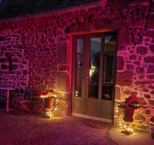 une porte menant à un bâtiment en briques avec des lumières à côté de celui-ci dans l'établissement Les naturelles, à Saint-Aubin-de-Locquenay