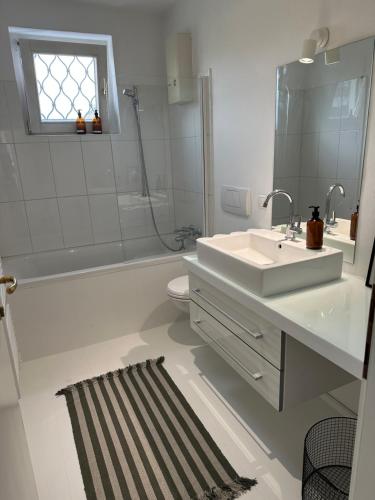 een badkamer met een wastafel, een bad en een toilet bij Casa Móre GRAY in Niederalm