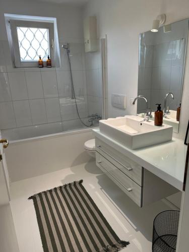 a bathroom with a sink and a tub and a toilet at Casa Móre GRAY in Niederalm