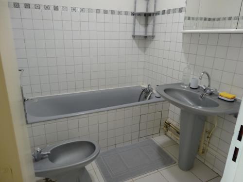 a bathroom with a sink and a tub and a toilet at Jennifer in Paris