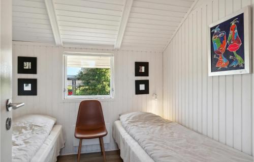 Un dormitorio con 2 camas y una silla. en Cozy Home In Ebeltoft With Kitchen, en Ebeltoft