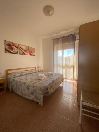 a bedroom with a bed and a window at Lemon Apartments in Villasimius