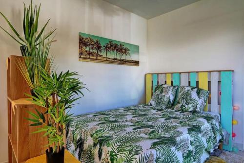 a bedroom with a bed and some plants at Studio La Tortue in Saint-Gilles les Bains