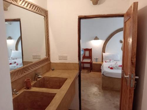 a bathroom with a tub and a large mirror at Boutique Hotel Nyumbani Tembo in Watamu
