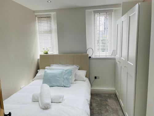 a bedroom with a bed with white sheets and pillows at 1 Bedroom Sea side luxury in New Brighton