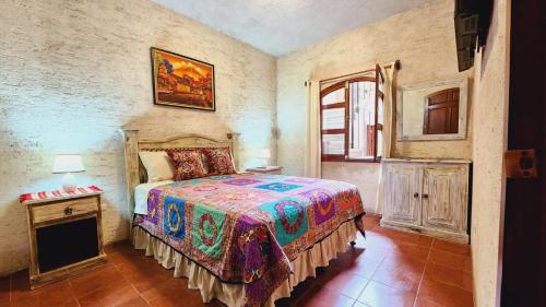 Schlafzimmer mit einem Bett, einem Tisch und einem Fenster in der Unterkunft Casa Miranda in Antigua Guatemala