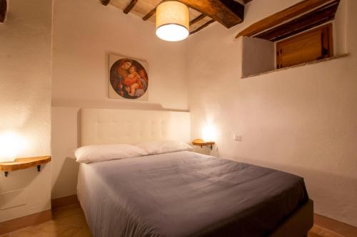 een slaapkamer met een bed en een schilderij aan de muur bij La Vernaccia - Torre del Colle, Bevagna in Torre del Colle