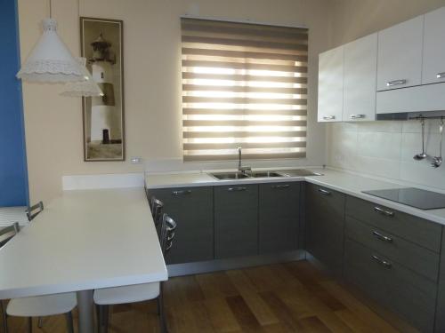 een keuken met een wit aanrecht en een wastafel bij Sole e mare in Castellaneta Marina 