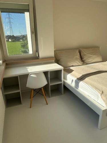 a bedroom with a bed and a desk and a window at Casa Móre BEIGE in Niederalm