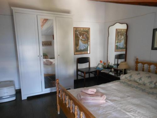a bedroom with a bed and a chair and a mirror at Mansion at Chora in Andros in Andros