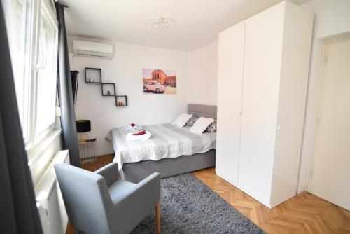 1 dormitorio con 1 cama y 1 silla en GretaNola studio in Zagreb, parking, self check-in, en Zagreb