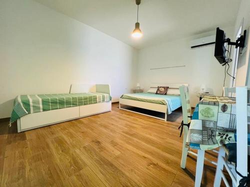 2 Betten in einem Zimmer mit Holzboden in der Unterkunft Domo Mea in La Caletta