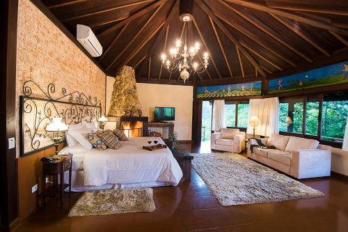 um quarto com uma cama e um lustre em Maua Brasil Hotelaria em Visconde de Mauá