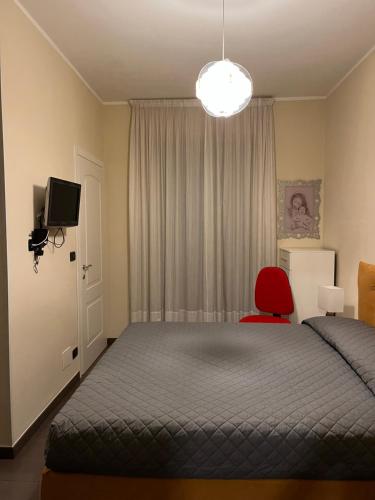 a bedroom with a bed and a red chair at Casa Silli in Pinerolo