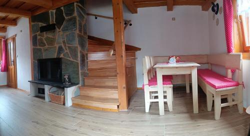 a living room with a table and a fireplace at Dolná chata u Bratríkov in Haligovce