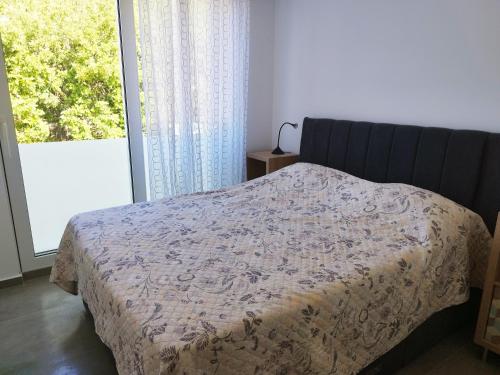 a bedroom with a bed and a large window at M&D appartments in Komiža