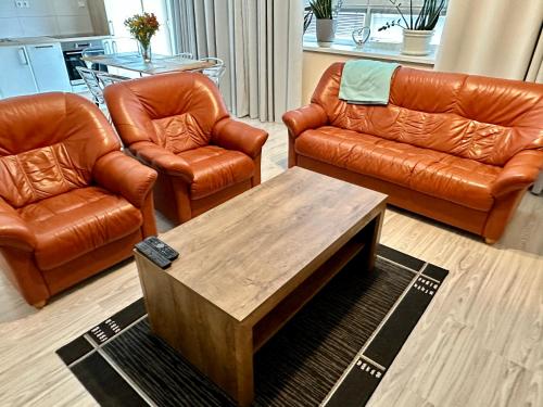 a living room with leather furniture and a coffee table at Princess City Centre Apartment in Poprad