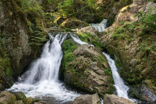 a group of waterfalls flowing through a rocky canyon at GITE LA FERMETTE A DOCELLES in Docelles