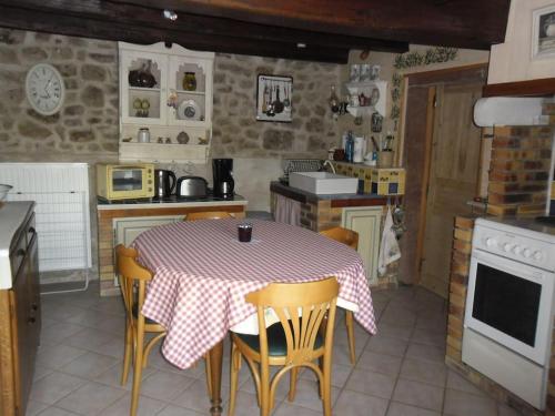 a kitchen with a table and chairs in a kitchen at GITE LA FERMETTE A DOCELLES in Docelles
