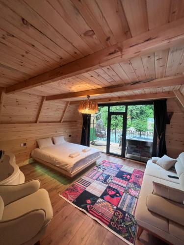 a bedroom in a log cabin with a bed and a rug at Elegant Bungalov in Rize